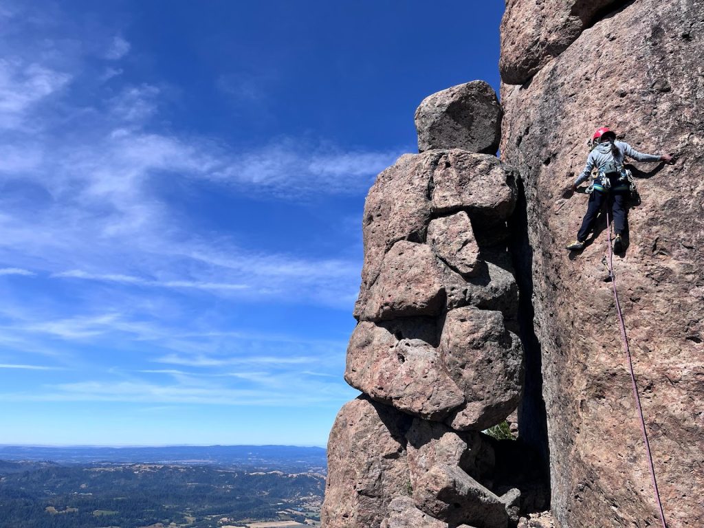 Woman climbing rock wall.